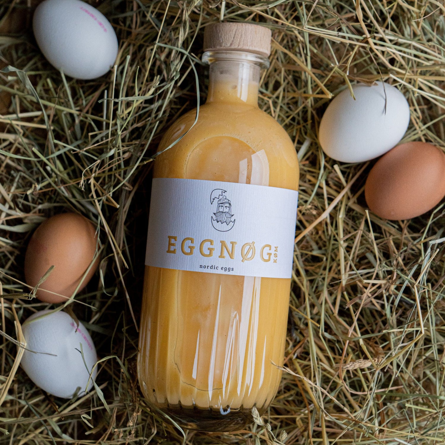 Eggnog Flasche im Heu mit Eier als Deko