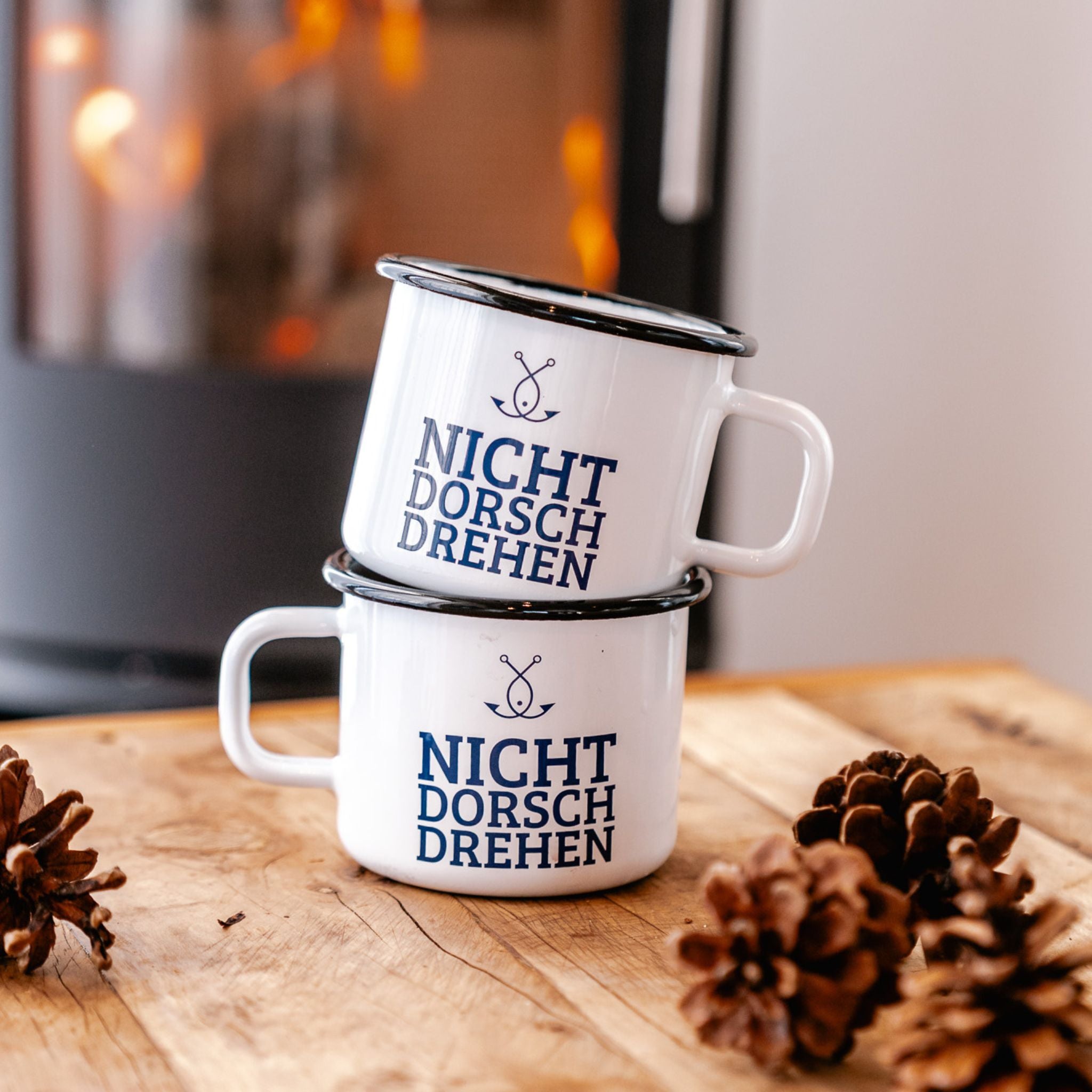 Zwei Emaillebecher „NICHT DORSCHDREHEN“ auf Holz mit Tannenzapfen – nordisches Geschenk mit Humor
