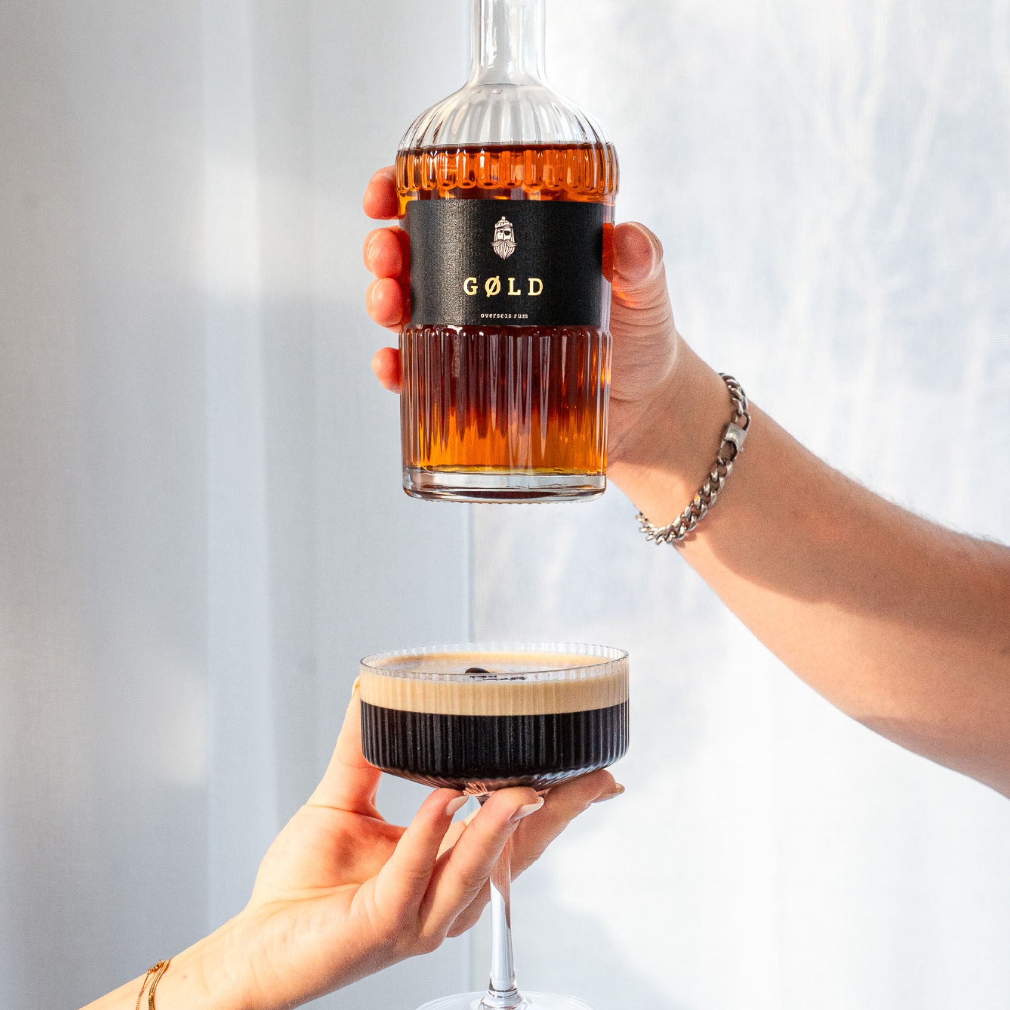 GØLD Overseas Rum Flasche über einem Espresso Martini Cocktail drapiert