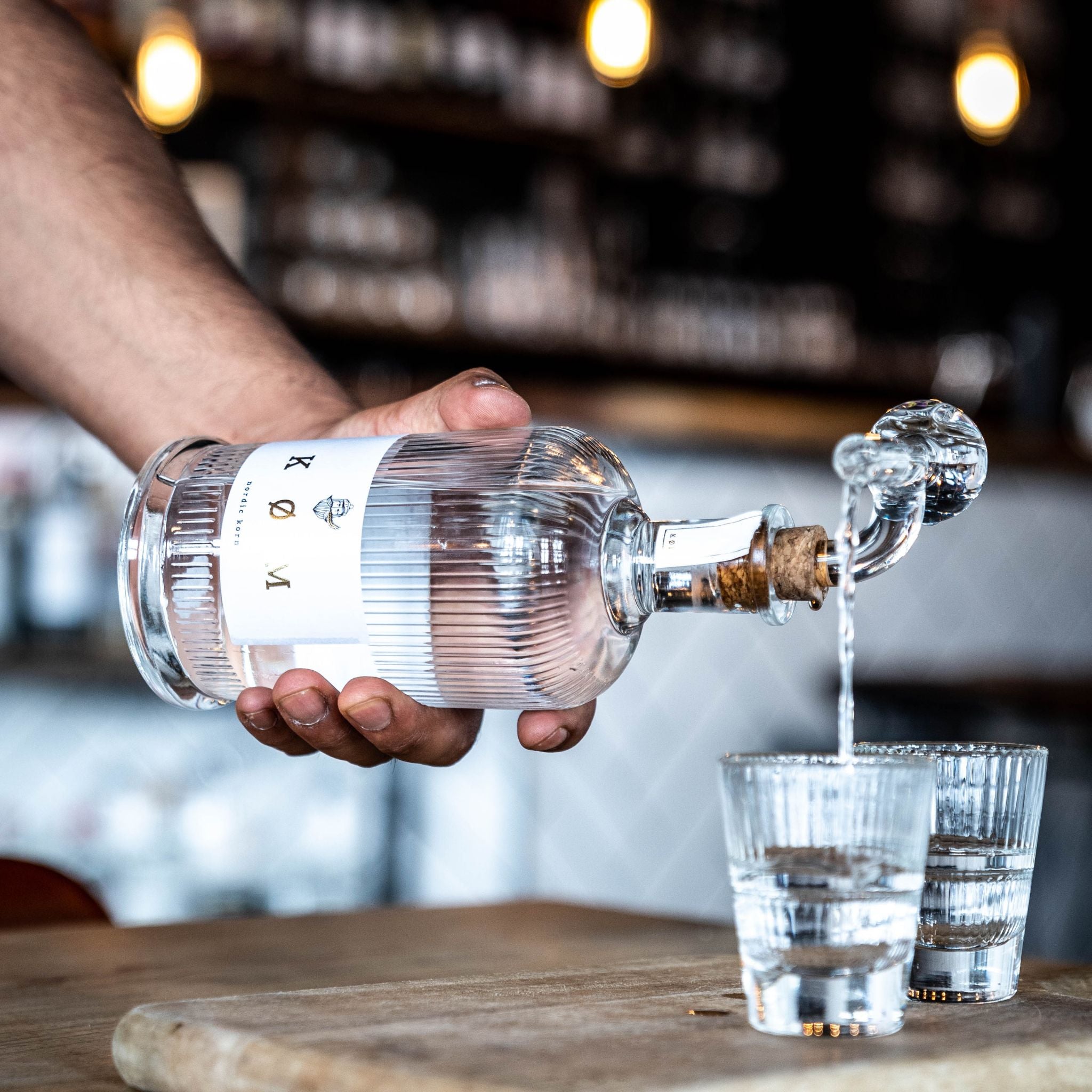 KØM Nordic Korn wird in Glas eingeschenkt an einer Bar mit warmem Licht