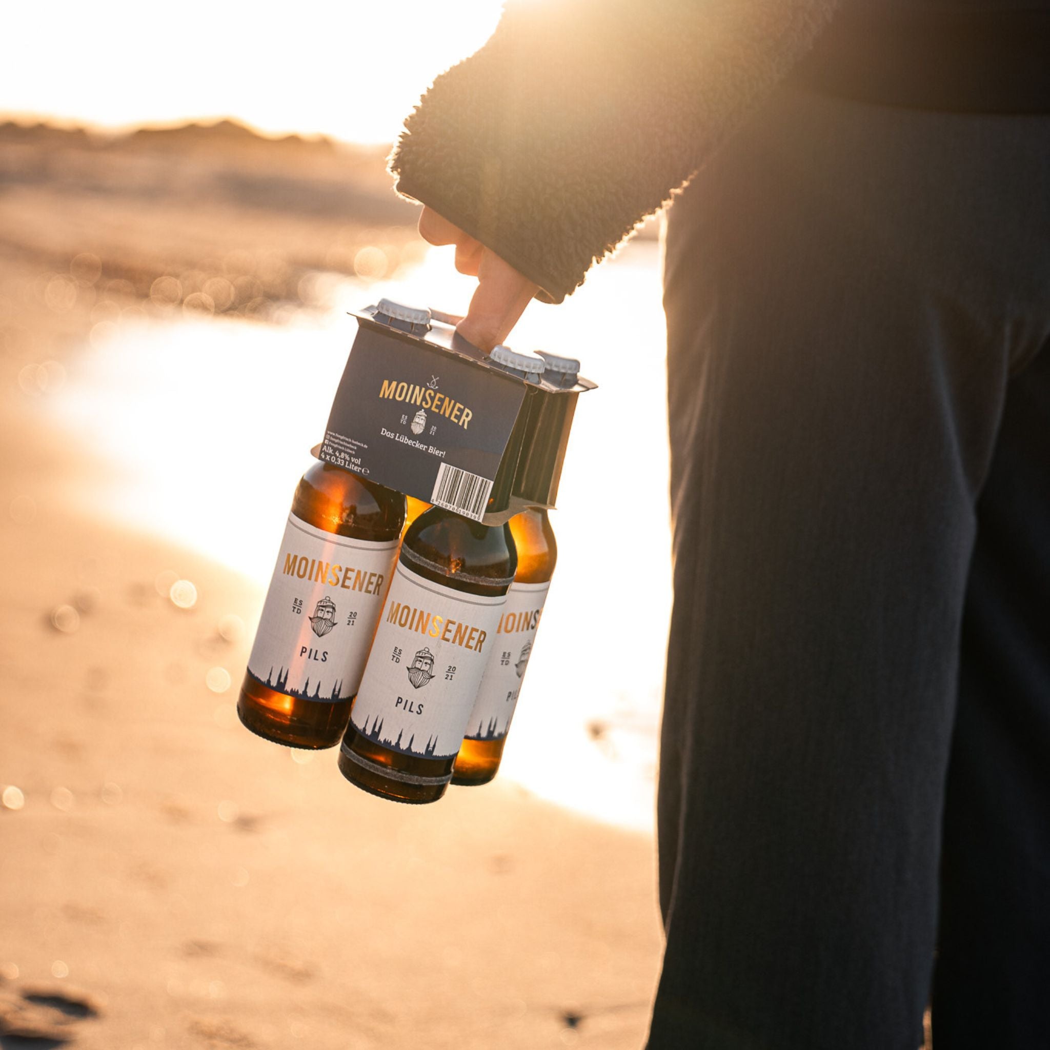 Moinsener Pils am Strand als 4er getragen