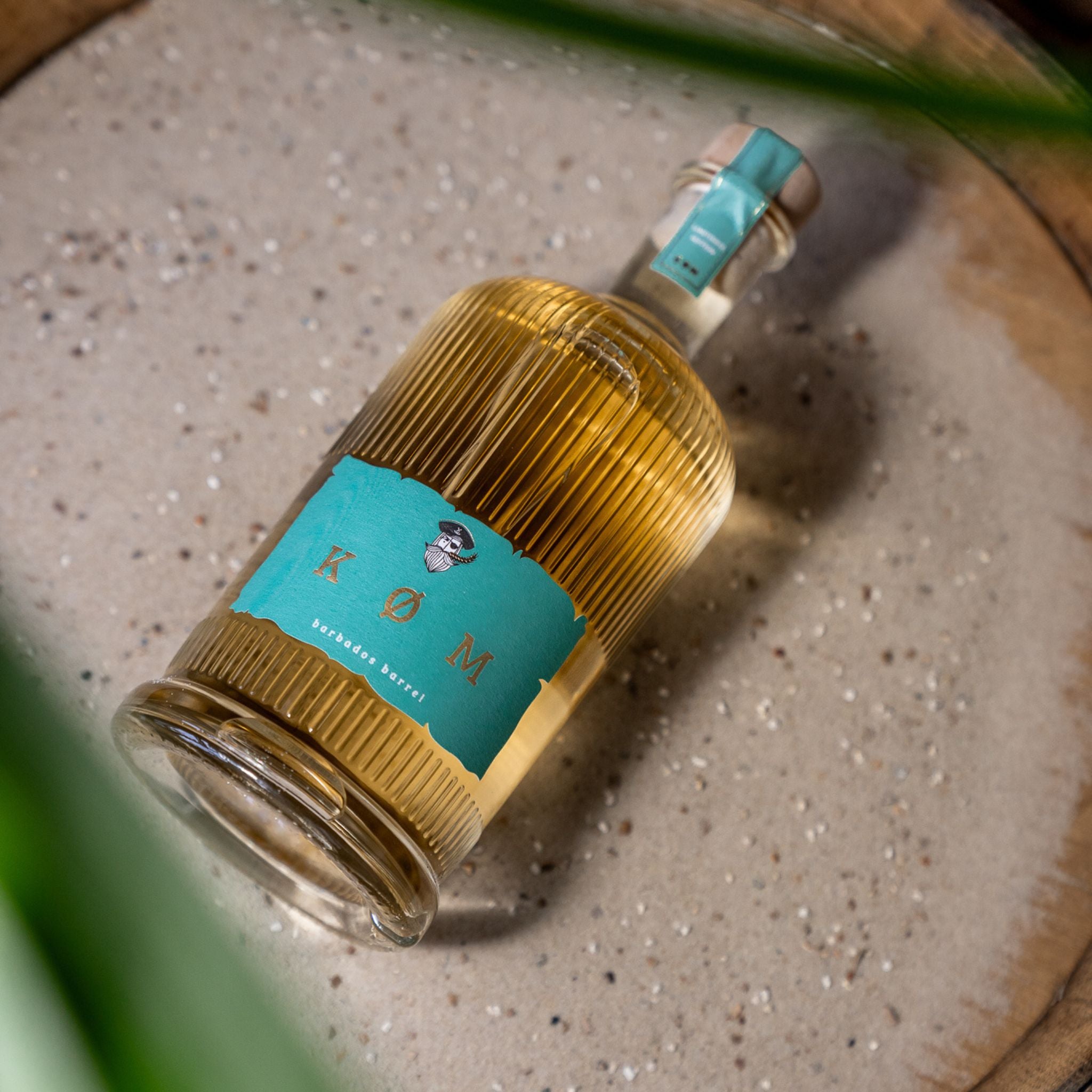 Flasche KØM BARBADOS BARRELL drapiert auf Ostseesand