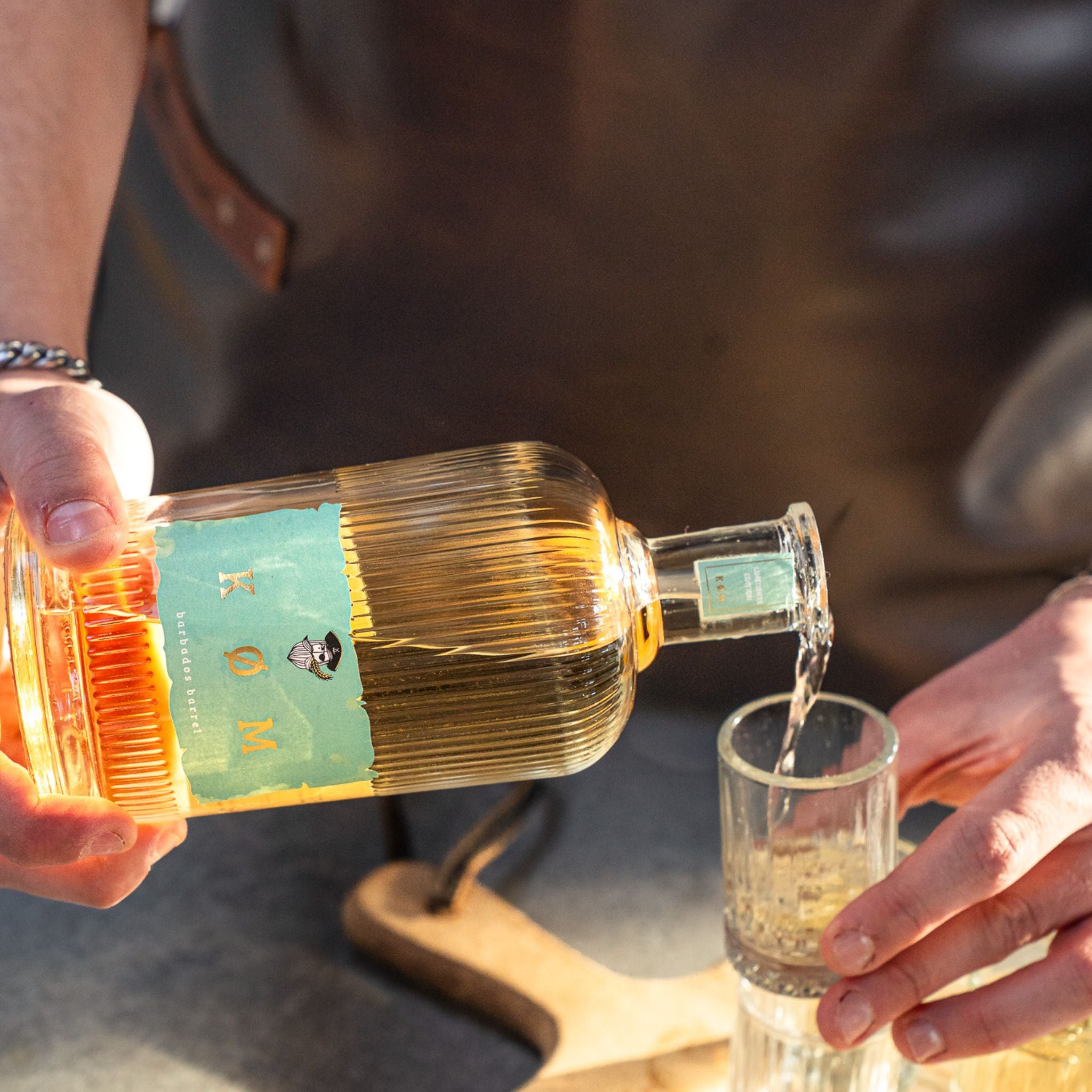 Ein Schnapsglas wird mit einer Flasche KØM BARBADOS BARRELL befüllt