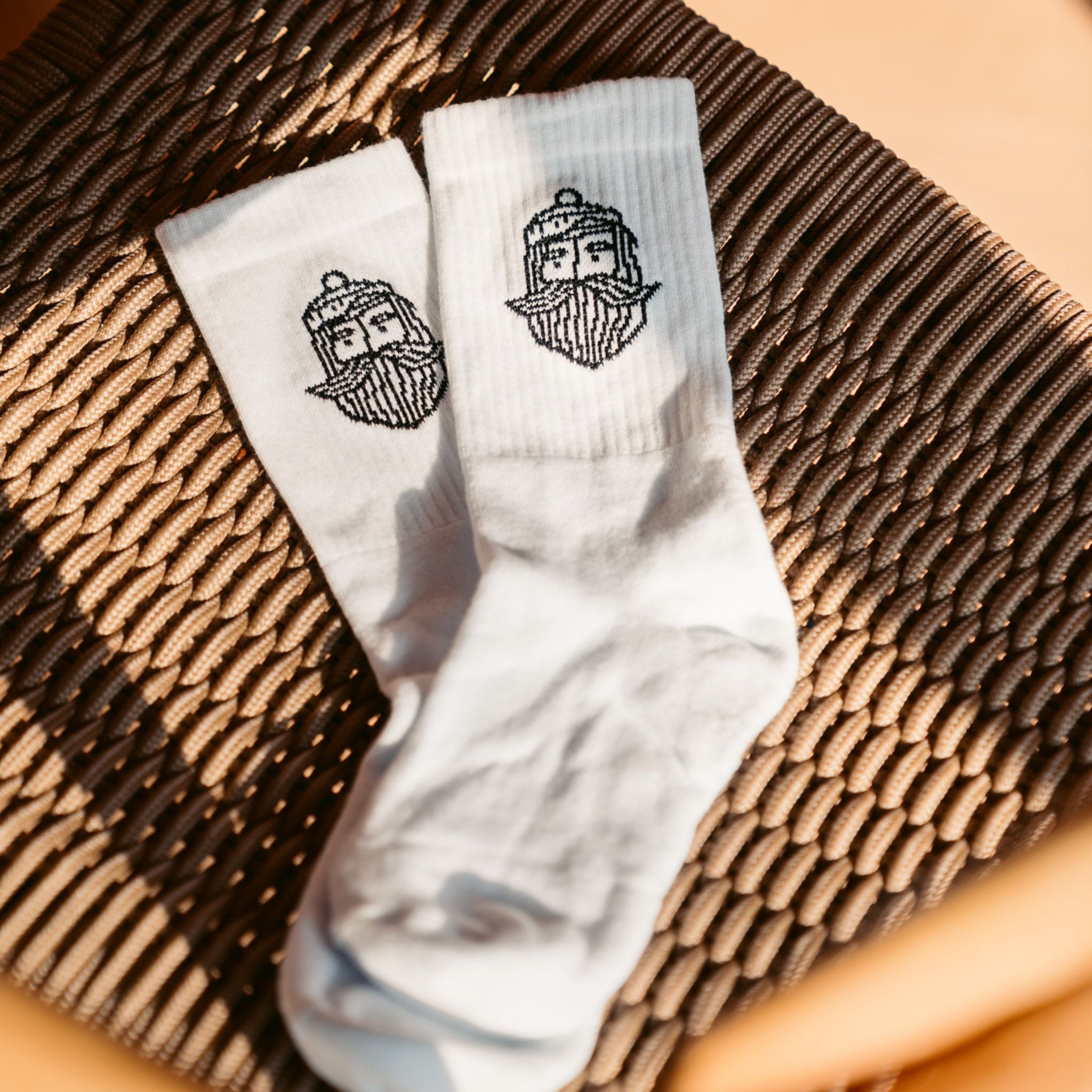 Weiße Socken mit Matrosen-Logo als Produktbild auf hellem Hintergrund