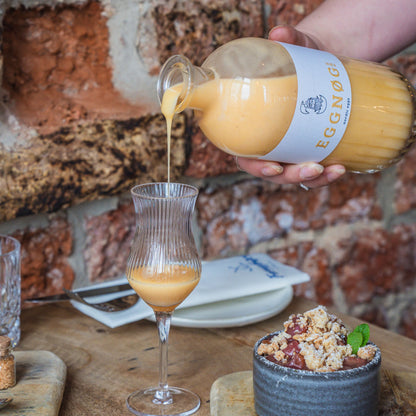 EGGNØG KØM Eierlikör wird in ein Glas eingeschenkt