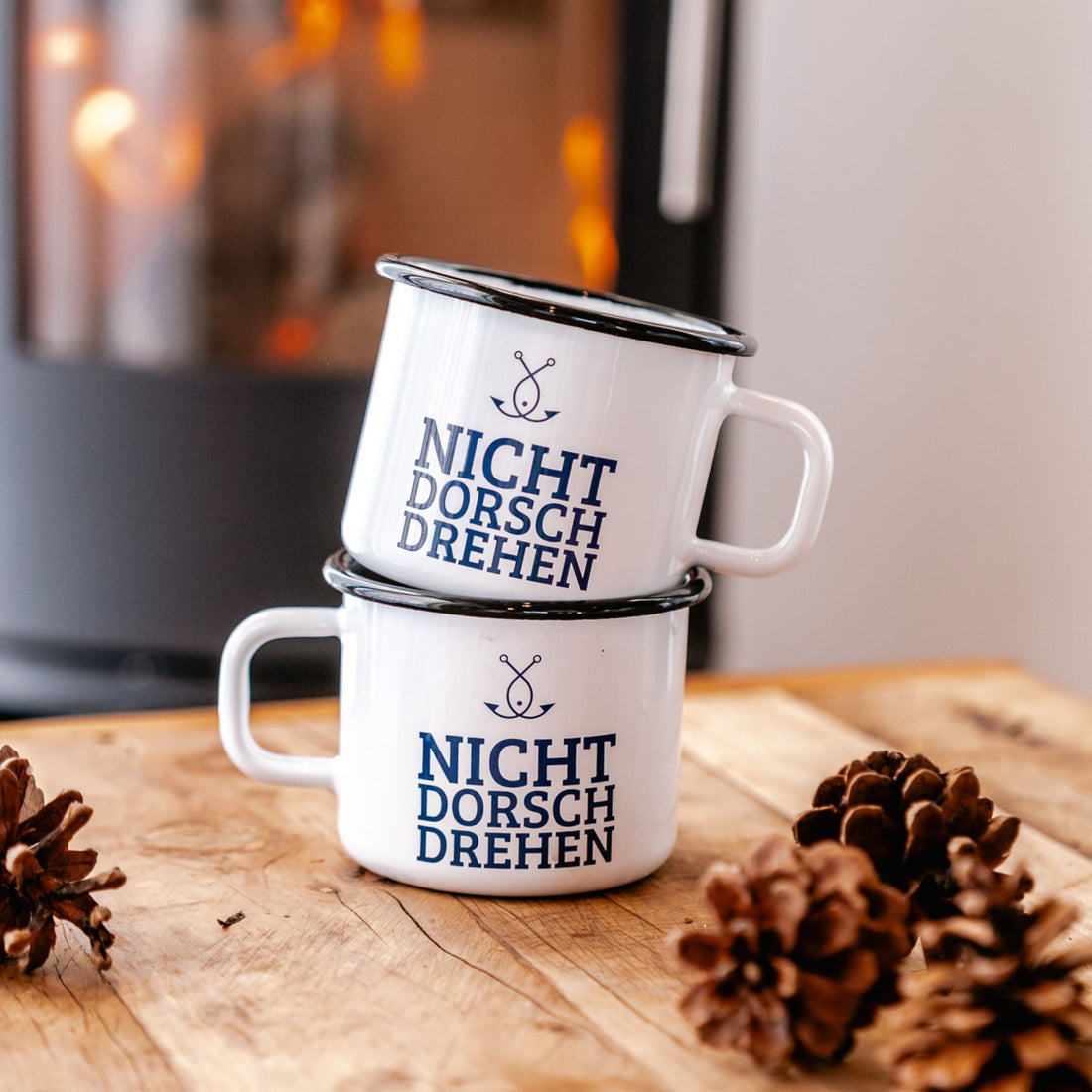 Zwei Emaillebecher „NICHT DORSCHDREHEN“ auf Holz mit Tannenzapfen – nordisches Geschenk mit Humor