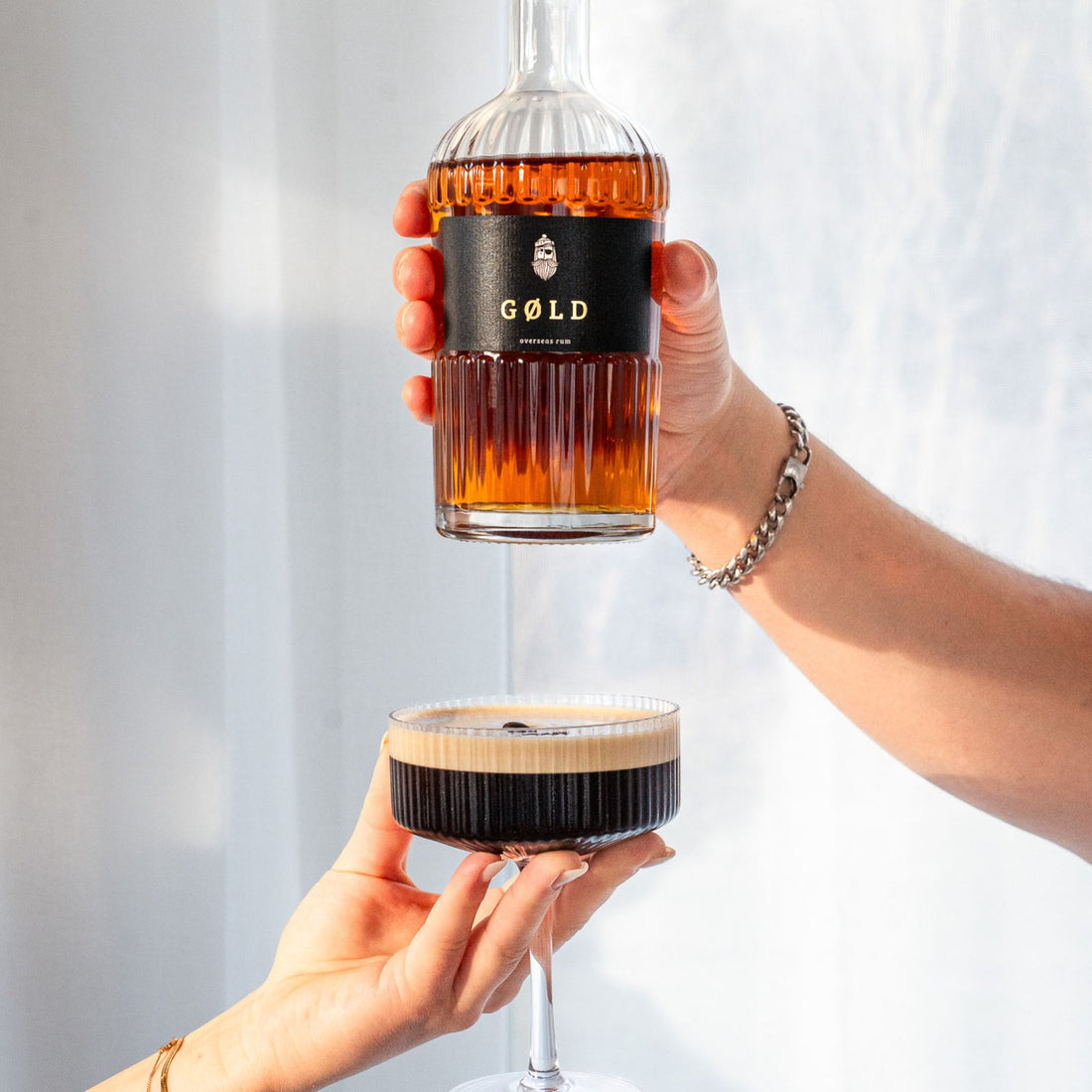 GØLD Overseas Rum Flasche über einem Espresso Martini Cocktail drapiert