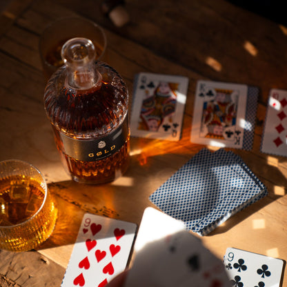 Inszenierte Glücksspielszene mit GØLD Overseas Rum Flasche und Rumgläsern mit Eiswürfeln