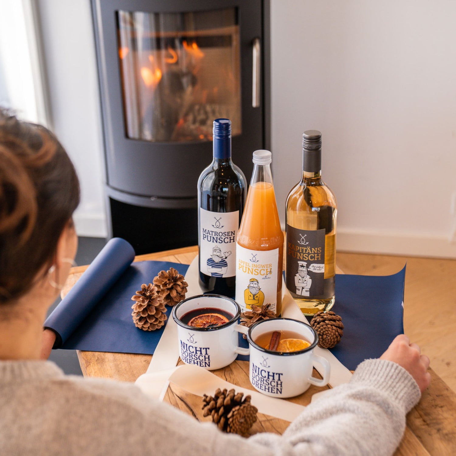 Geschenkset mit Glühwein und Punsch vor Kamin, gemütliche Winterstimmung