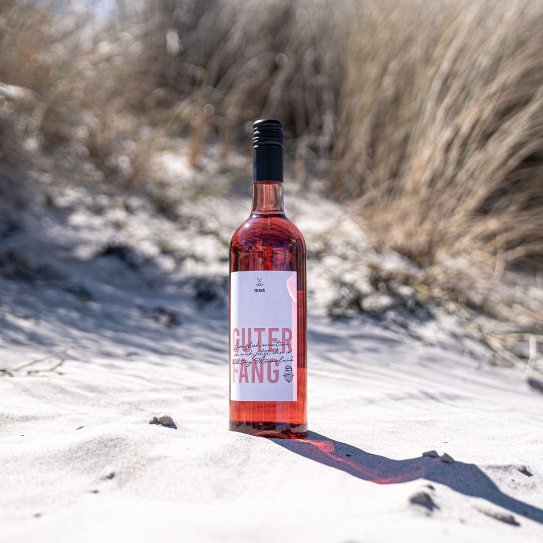 Guter Fang Rosé Flasche im Sand am Strand – Sommerwein