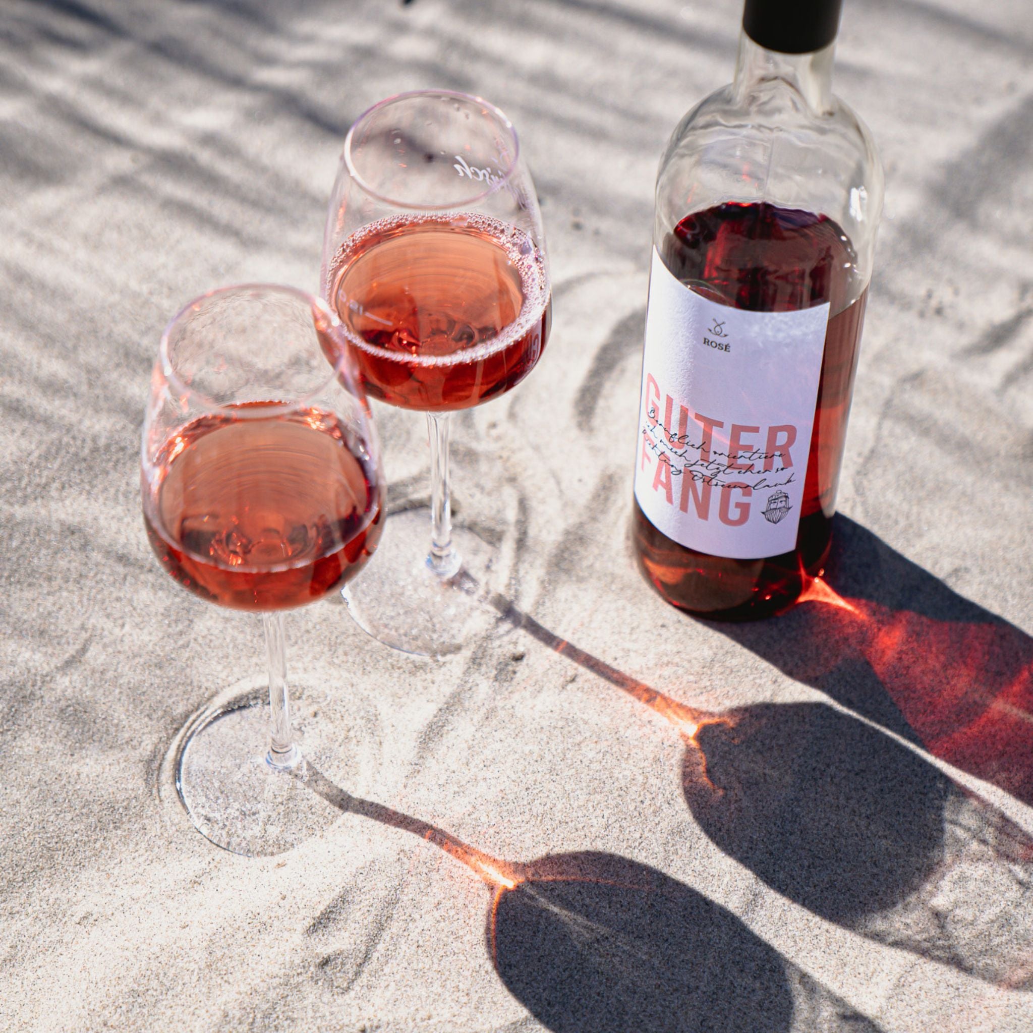 Rosé Wein Gläser im Sand neben Flasche – Strandmoment