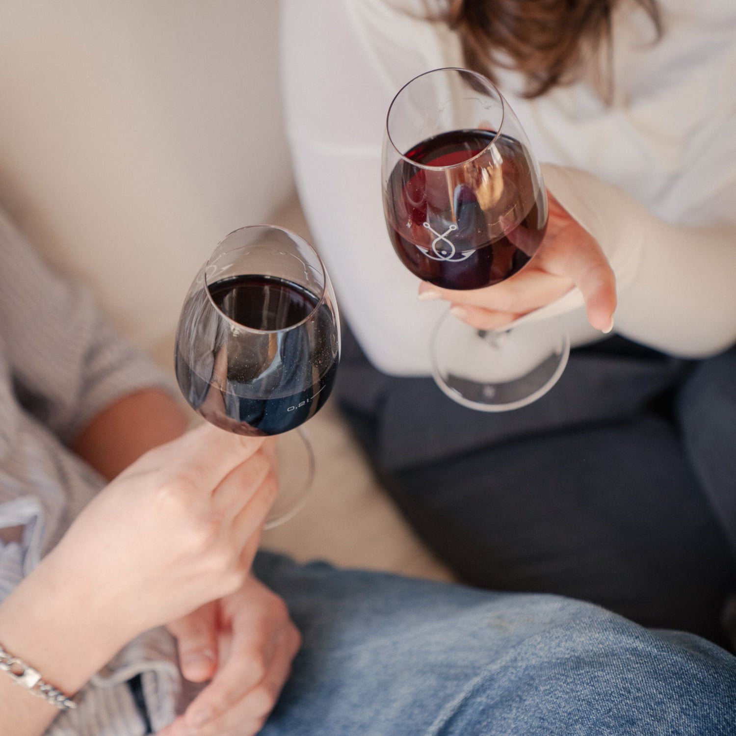 Zwei Personen stoßen mit Guter Fang Rotwein an