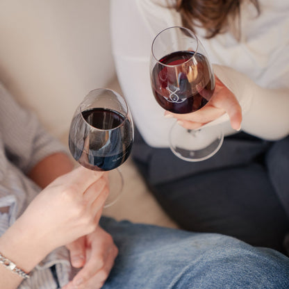 Zwei Personen stoßen mit Guter Fang Rotwein an