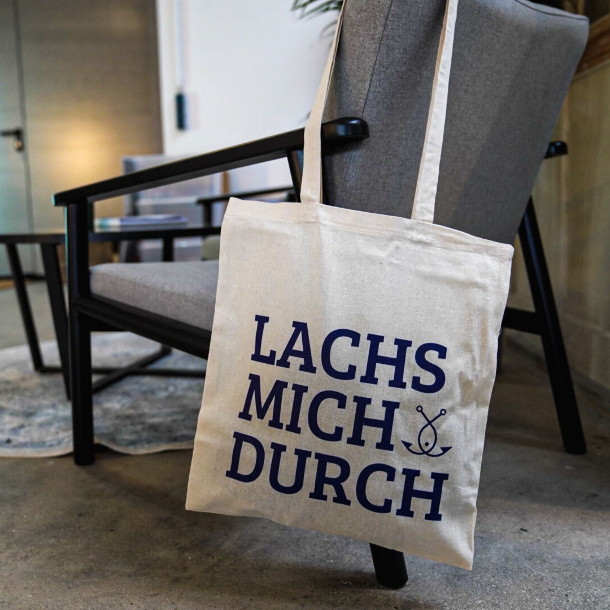 Jutebeutel mit Aufdruck LACHS MICH DURCH an Sessel – Fangfrisch