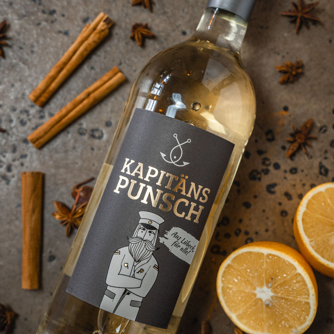 Kapitänspunsch Flasche mit Gewürzen und Orange auf dunklem Untergrund