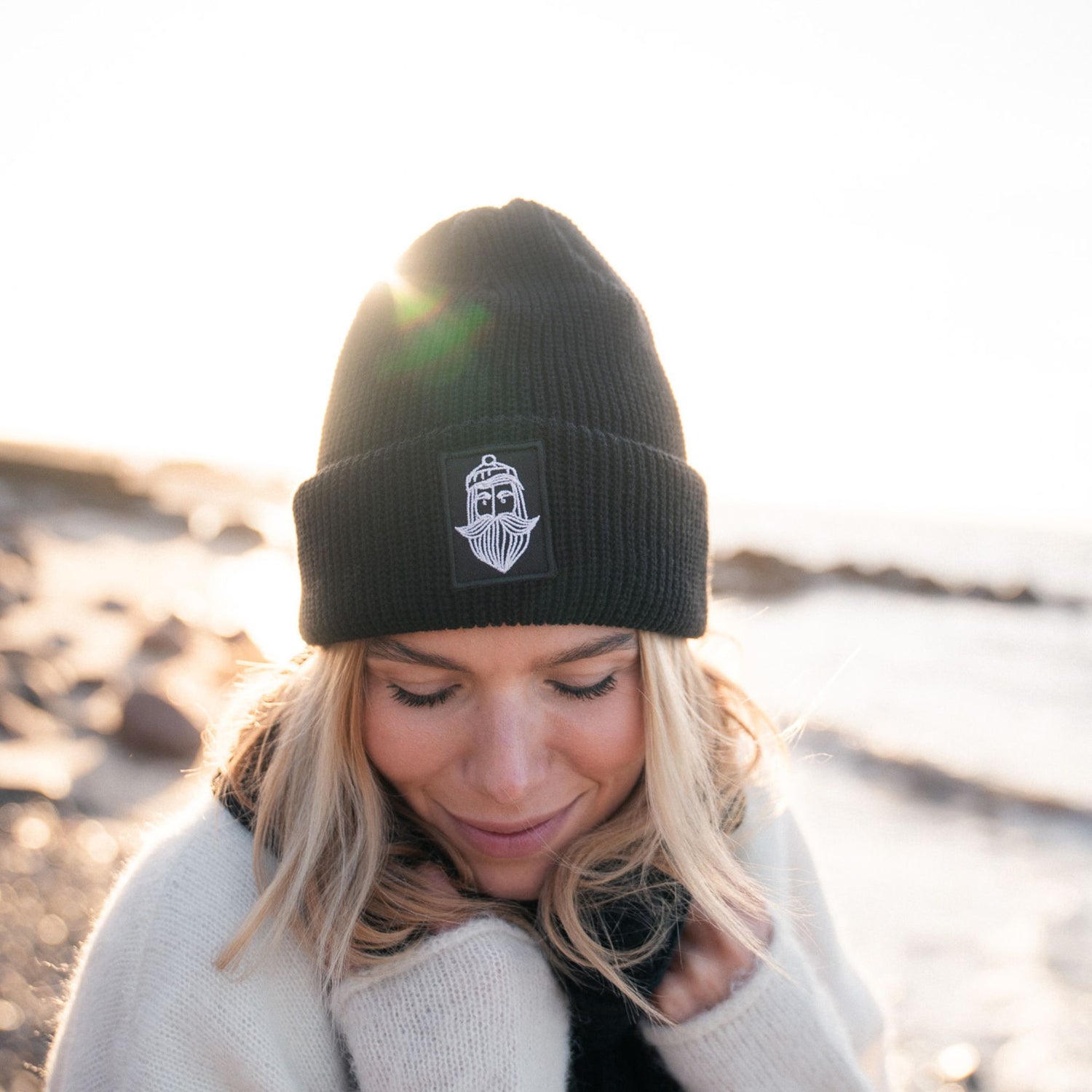 Matrosenmütze aus schwarzer Wolle mit handaufgenähtem Patch am Strand