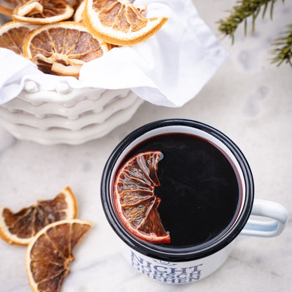 Tasse mit heißem Matrosenpunsch und Orangenscheibe, winterliche Stimmung mit getrockneten Zitrusfrüchten