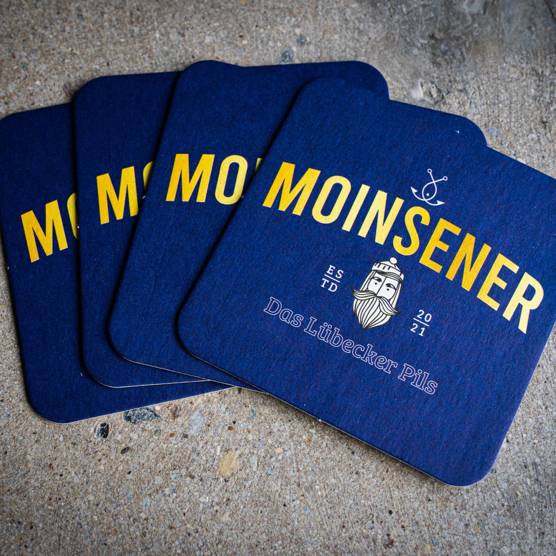Moinsener Bierdeckel Set mit vier Deckeln auf hellem Hintergrund