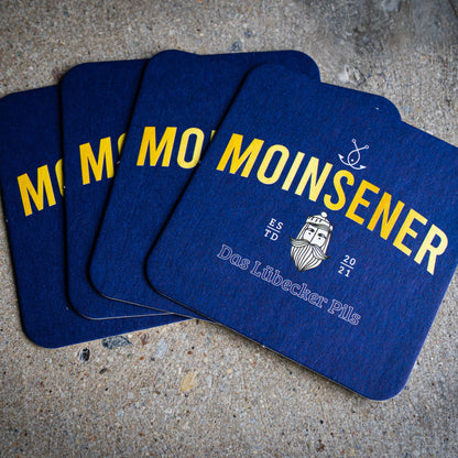 Moinsener Bierdeckel Set mit vier Deckeln auf hellem Hintergrund