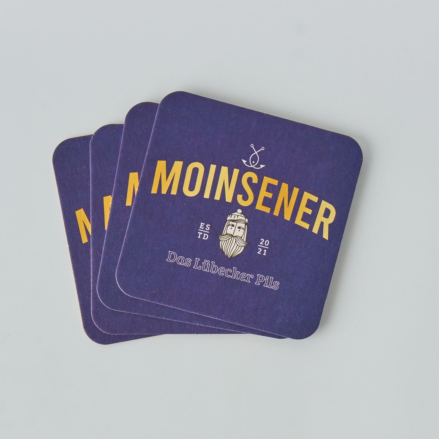 Moinsener Bierdeckel Set mit vier Deckeln auf hellem Hintergrund