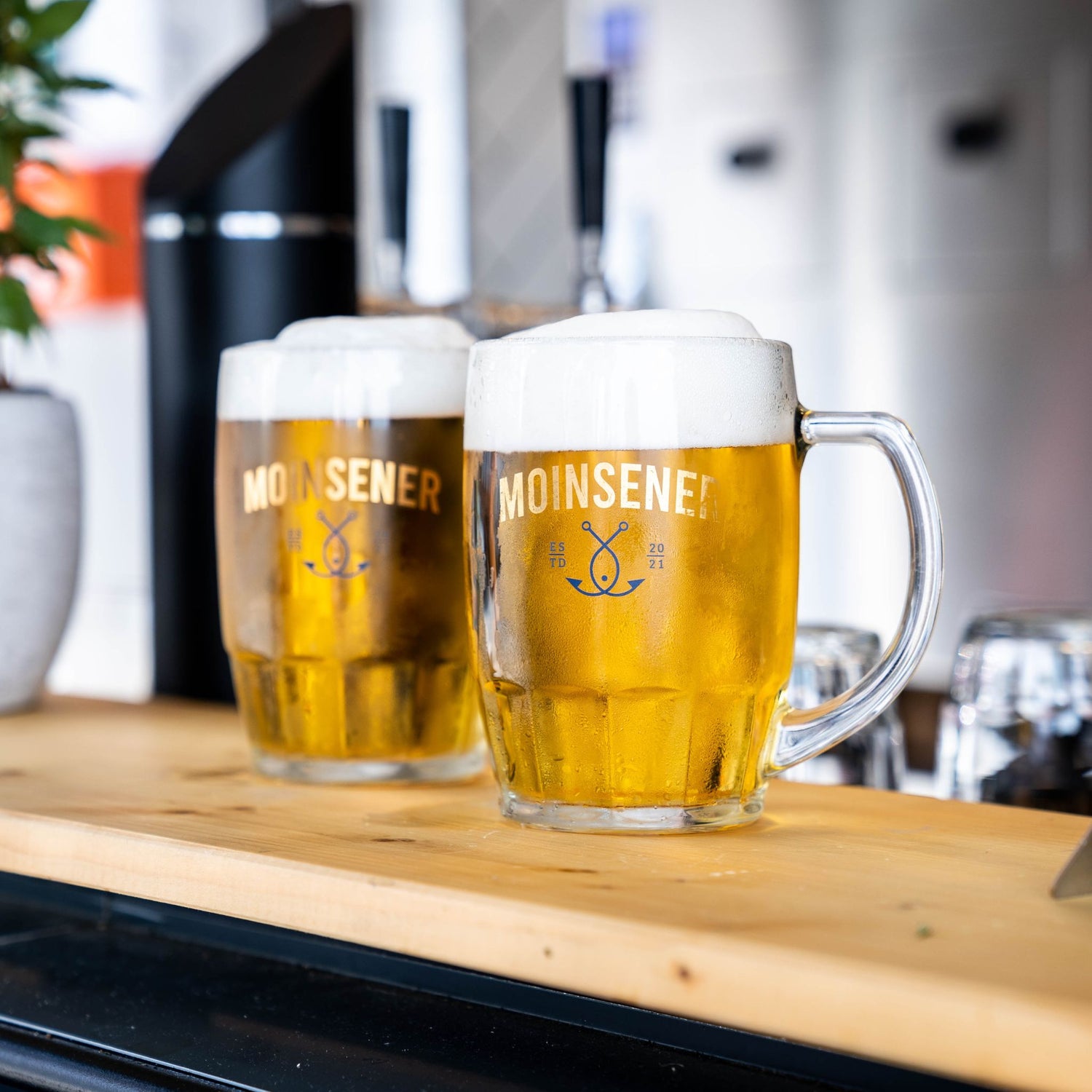 Moinsener Bierkrug mit frisch gezapftem Bier auf Tresen