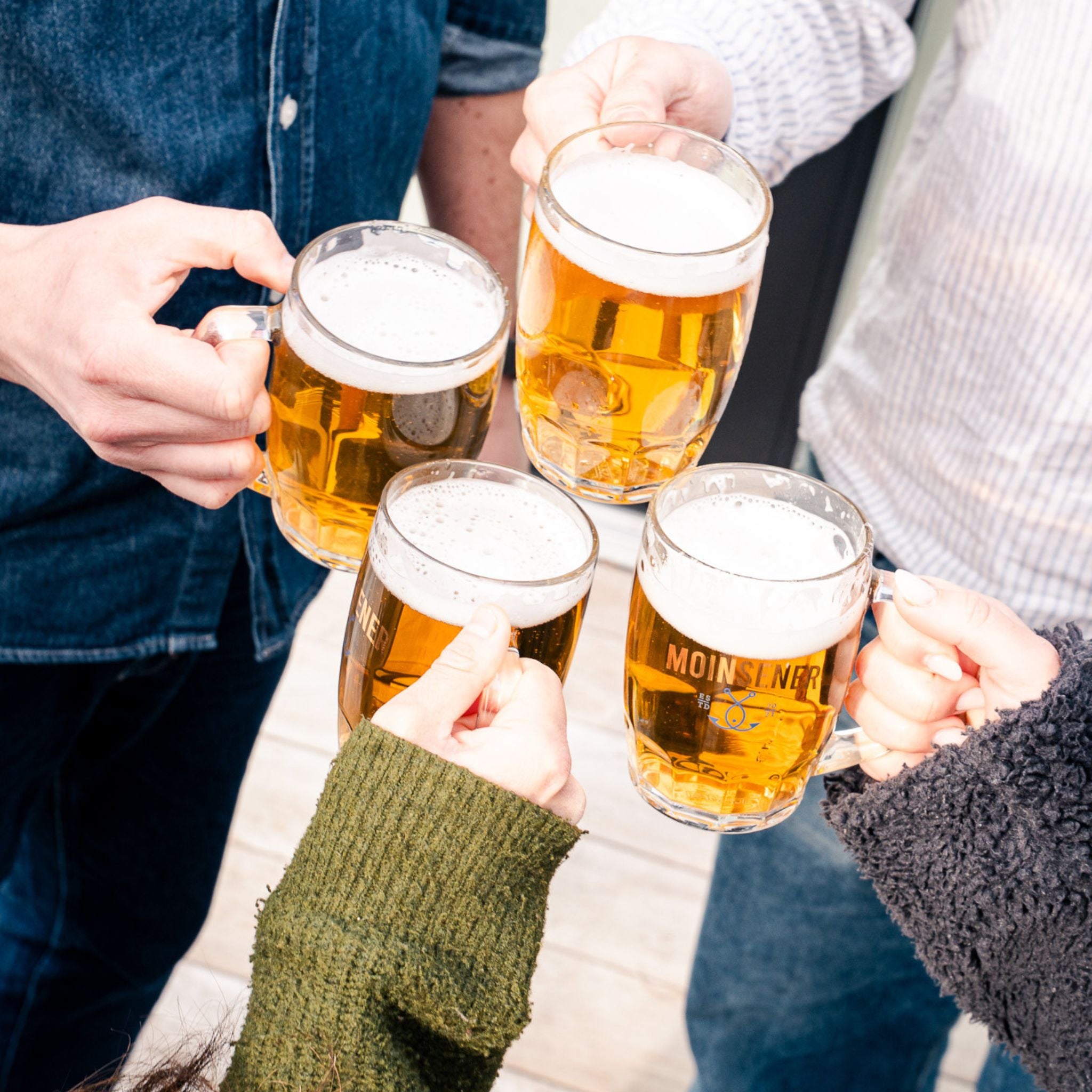 Moinsener Bierkrug von oben beim gemeinsamen Anstoßen