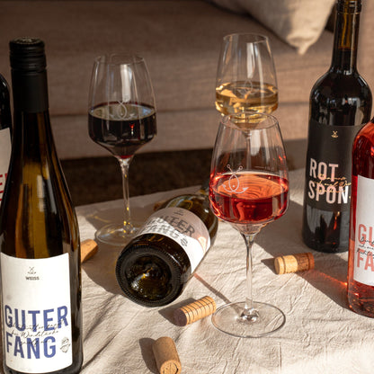 Weinreise Geschenkset von Fangfrisch auf Tisch mit Weingläsern und Flaschen – perfekt zum Probieren