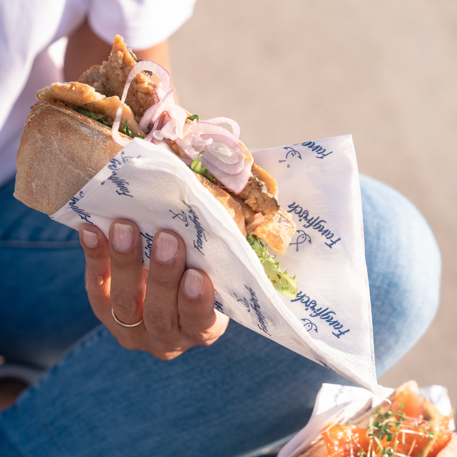 Frisch zubereitetes Fischbrötchen von Fangfrisch Lübeck in der Hand