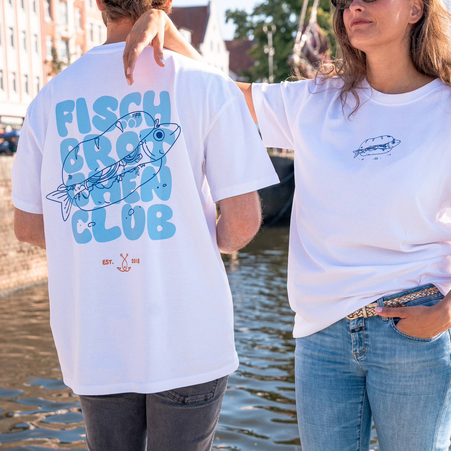 Paar mit Fischbrötchenclub T-Shirts Rücken- und Frontansicht in der Lübecker Altstadt